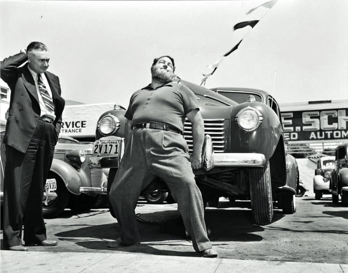 Leavitt lifting a car in an L.A. sales lot.